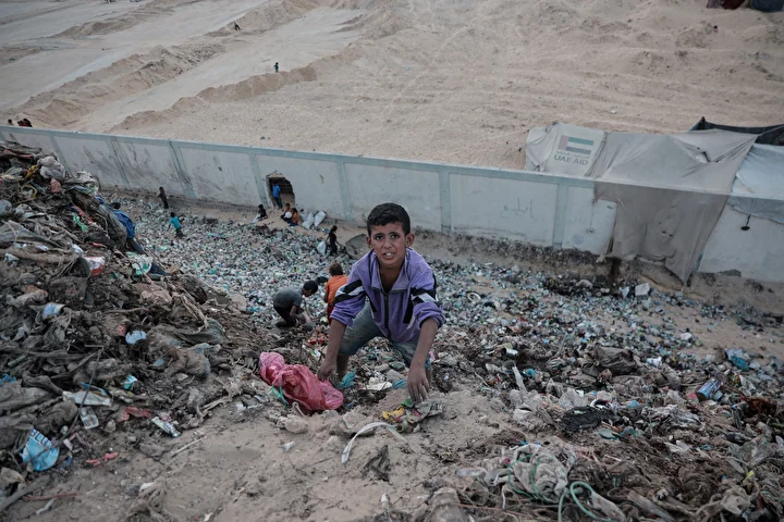 israil taarruzlari altindaki gazzede cocuklar ailelerinin gecimine takviye olmak icin cop topluyor 23 dugKMNkH